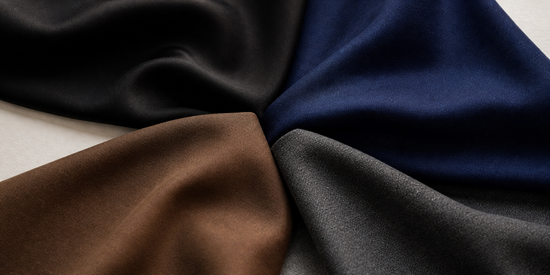 Equal black, navy, brown and charcoal fabrics arranged together for reviewing colour coordination.
