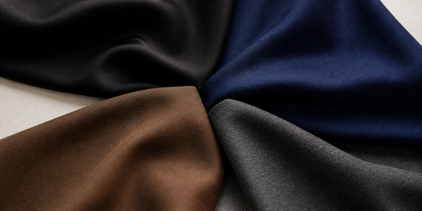 Equal black, navy, brown and charcoal fabrics arranged together for reviewing colour coordination.