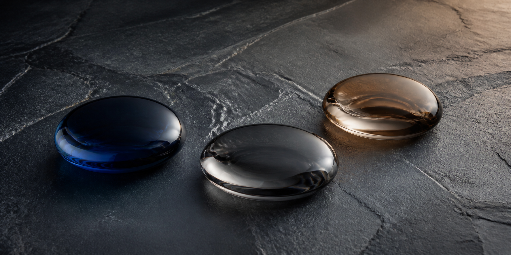 Three equal charcoal and slate glass forms arranged in a gentle arc for a KLAPP Men routine-context guide.